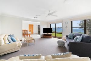 a living room with couches and a flat screen tv at Norah Head Seascape in Norah Head