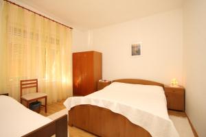 a bedroom with two beds and a cabinet and a window at Apartments by the sea Ugljan - 348 in Ugljan