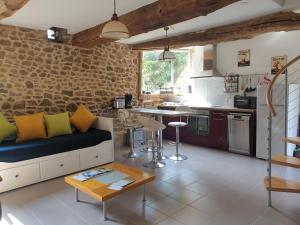 a living room with a couch and a kitchen at Gîte Le Valet, T2 classé 3 étoiles, entre Rennes et Saint-Malo in La Chapelle-aux-Filzméens +18 photos