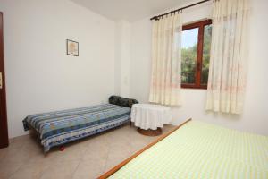 sypialnia z 2 łóżkami, stołem i oknem w obiekcie Apartment Mala Lamjana 827b w mieście Kali