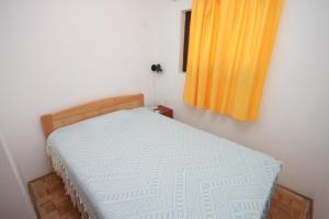 a small bed in a room with a curtain at Seaside holiday house Veli Rat, Dugi otok - 875 in Veli Rat