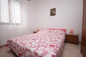 - une chambre dotée d'un lit avec une couverture rouge et blanche dans l'établissement Apartments by the sea Cove Mala Lamjana, Ugljan - 827, à Kali