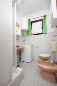 La salle de bains est pourvue de toilettes, d'un lavabo et d'une baignoire. dans l'établissement Apartments by the sea Cove Mala Lamjana, Ugljan - 827, à Kali