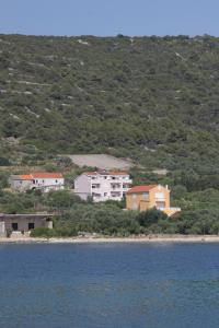 un groupe de maisons sur une colline à côté de l'eau dans l'établissement Apartments and rooms by the sea Cove Soline, Dugi otok - 448, à Veli Rat