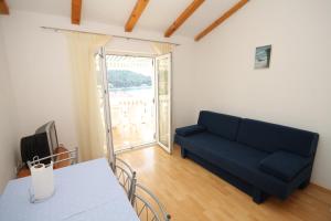 a living room with a blue couch and a window at Apartments and rooms by the sea Cove Soline, Dugi otok - 448 in Veli Rat