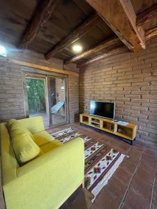 Il comprend un salon doté d'un canapé et d'une télévision à écran plat. dans l'établissement Casa Regina Oaxaca, à San Pablo Villa de Mitla