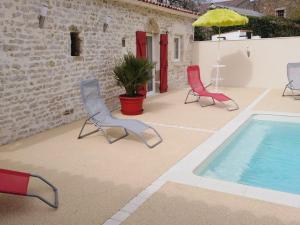 a patio with two chairs and a swimming pool at Gîte L'Hermenault, 8 pièces, 14 personnes - FR-1-426-362 in LʼHermenault