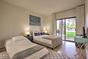 a bedroom with two beds and a flat screen tv at Access to 33 Pools Cathedral City Condo with Patio in Cathedral City