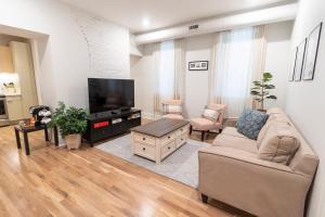 a living room with a couch and a flat screen tv at Spacious 2 bed 2 bath Downtown OTR condo minutes walk to the Reds Bengals stadium & more! in Cincinnati