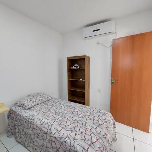 1 dormitorio con cama y puerta marrón en Chales do delta Piauí, en Parnaíba