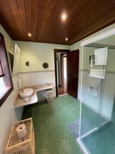 Un baño con ducha de cristal y lavabo. en Bela vista - Secretário, en Petrópolis