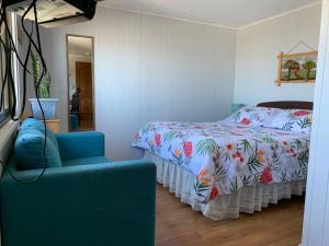 um quarto com uma cama, uma cadeira e um espelho em Cabañas Tía Elsa em Puerto Saavedra