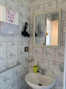 uma casa de banho com um lavatório e um espelho em Cabañas Tía Elsa em Puerto Saavedra