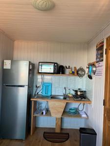 uma pequena cozinha com um frigorífico e um lavatório em Cabañas Tía Elsa em Puerto Saavedra