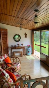 sala de estar con techo de madera y mesa en Aconchegante casa em Monte Verde, en Monte Verde