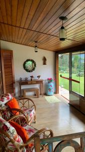 a living room with a wooden ceiling and a table at Aconchegante casa em Monte Verde in Monte Verde