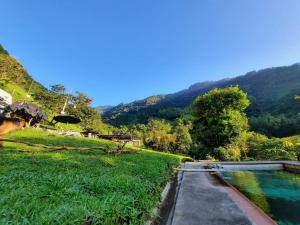a swimming pool in the middle of a field with a mountain at Casa Yantra La Lola in Pance
