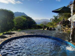 einen Pool mit einem Tisch und einem Sonnenschirm in der Unterkunft Casa Yantra La Lola in Pance