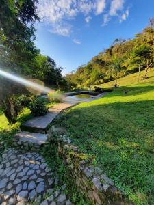 um caminho de pedra num parque com uma ponte em Casa Yantra La Lola em Pance