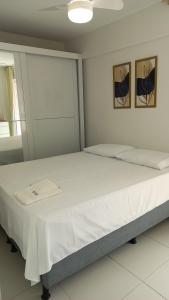 a bedroom with a large bed with white sheets at Apartamento Pé na areia em Tamandaré-Porto Cayman in Tamandaré