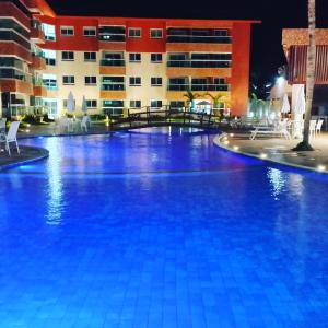 a large swimming pool in front of a building at Apartamento Pé na areia em Tamandaré-Porto Cayman in Tamandaré