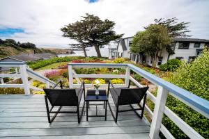 a wooden deck with chairs and a table on it at Agate Cove Inn in Mendocino
