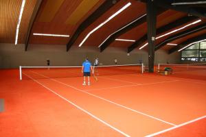 a man standing on a tennis court holding a racket at Landhotel Sonnenbühl in Sonnenbühl