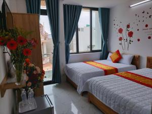 a hotel room with two beds and a window at Thảo Nguyên Hotel in Vung Tau