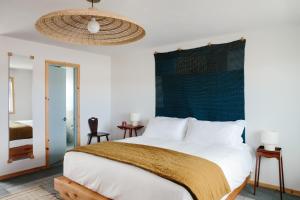 a bedroom with a large white bed with a green headboard at Daunts Albatross Motel in Montauk