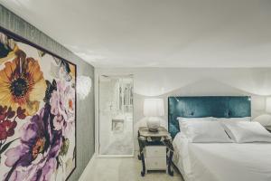 a bedroom with a bed and a flower painting on the wall at Deco Gem Bica in Lisbon