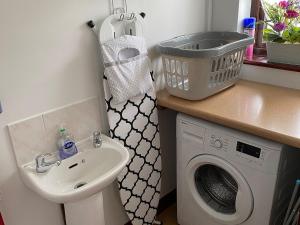 a bathroom with a sink and a washing machine at Highbury House in Camborne