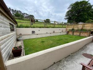 a backyard with a yard with a fence and a grassy field at Highbury House in Camborne