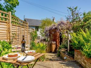 um jardim com uma mesa de madeira e uma cerca de madeira em Angel Lane em Woodbridge