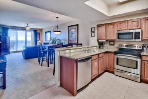 a kitchen with wooden cabinets and a living room at Beautiful beach home for a perfect vacation in Destin