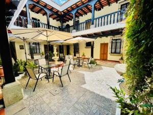 an outdoor patio with tables and chairs and umbrellas at Real Marquez Hotel in Antigua Guatemala