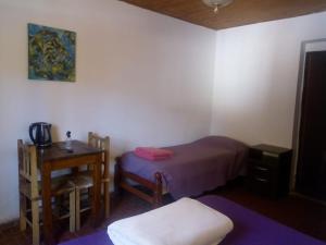 1 dormitorio con cama, mesa y escritorio en ElPoro en Purmamarca