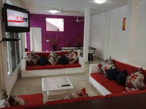 a living room with a red couch and a tv at quintaolivos Jardín y Alberca! in Alpuyeca