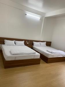 duas camas sentadas num quarto com em Nhà Nghỉ 68 Rạch Giá em Rạch Giá