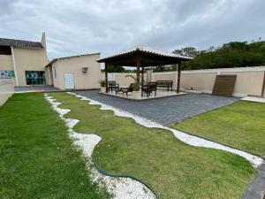 einen Garten mit einem Pavillon und einer Terrasse in der Unterkunft Beach House uma casa no Caribe brasileiro in Arraial do Cabo