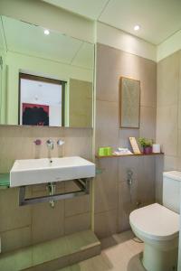 a bathroom with a sink and a toilet at Grandmas Plus Hotel Legian in Legian