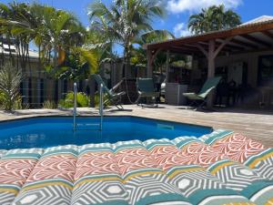 una piscina in un cortile con sedie e palme di Villa ATOLA a Le Diamant
