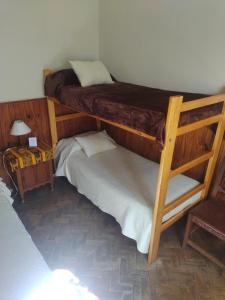 2 literas en una habitación con lámpara y mesa en Lo de Su, en Salta
