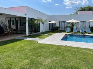 a house with a swimming pool and a yard at Casa Las Palmas in Ticumán