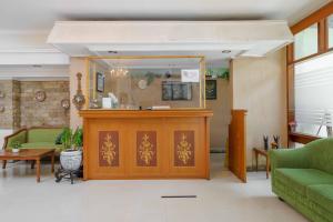 a lobby with a reception desk and a green couch at RedDoorz Plus near Kemang Raya in Jakarta