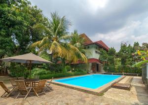 a swimming pool in front of a house at RedDoorz Plus near Kemang Raya in Jakarta