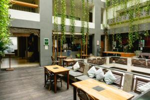 a patio with tables and chairs and tables and a building at Grandmas Plus Hotel Legian in Legian