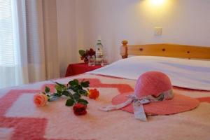 a pink hat and flowers on a bed at El Capitan in Porto Koufo