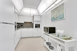 - une cuisine blanche avec des placards blancs et un réfrigérateur dans l'établissement THE TIDES 1bedroom apt 15th floor WE ARE ON THE BEACH!, à Hollywood