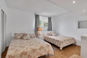 a white bedroom with two beds and a window at THE TIDES 1bedroom apt 15th floor WE ARE ON THE BEACH! in Hollywood