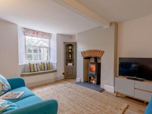 a living room with a blue couch and a fire place at Middle Cottage in Easton on the Hill